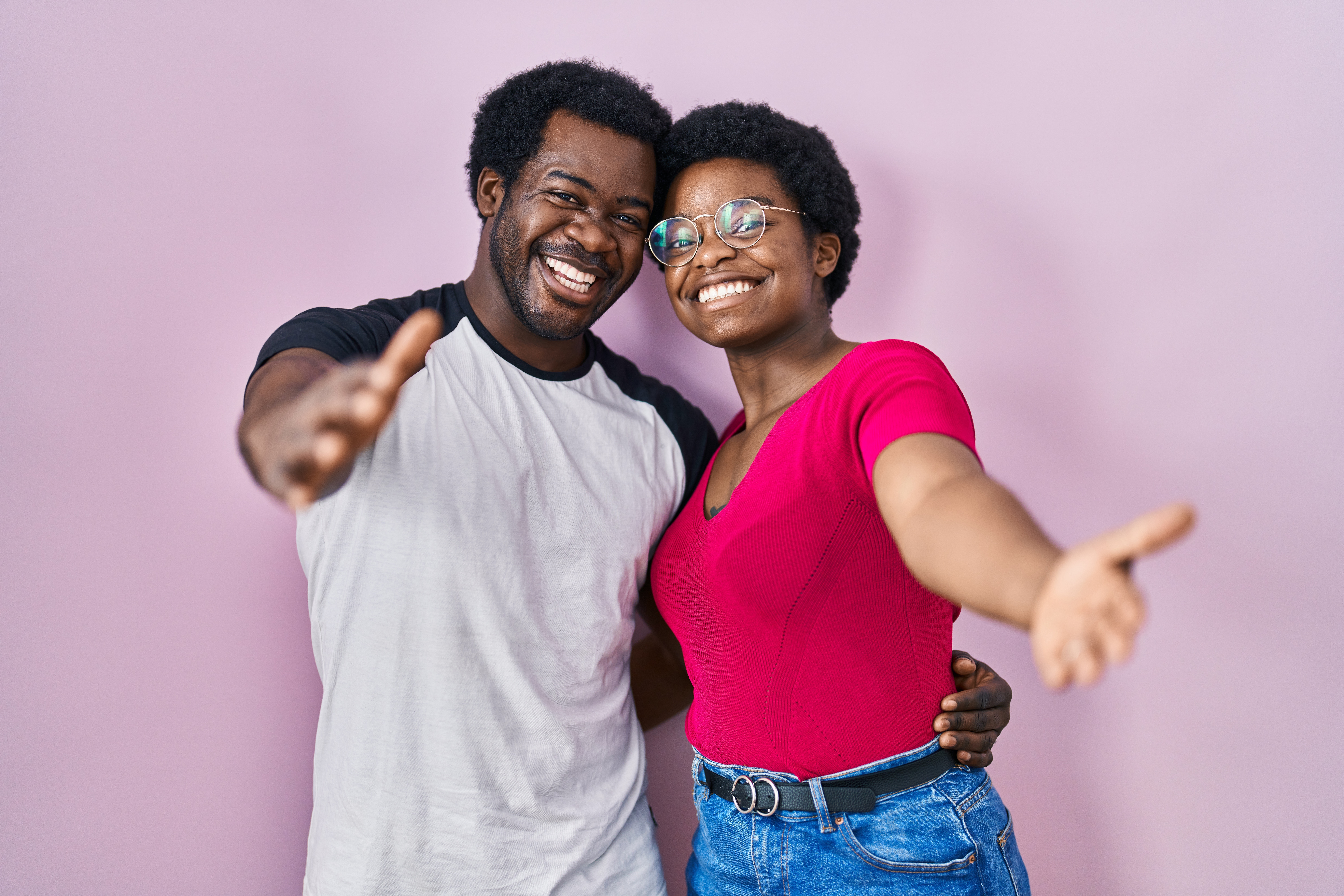 Young,African,American,Couple,Standing,Over,Pink,Background,Looking,At